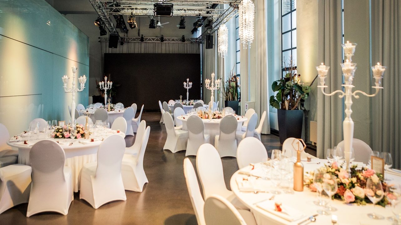 Bankettbestuhlung mit Kerzenleuchtern und Blumenschmuck