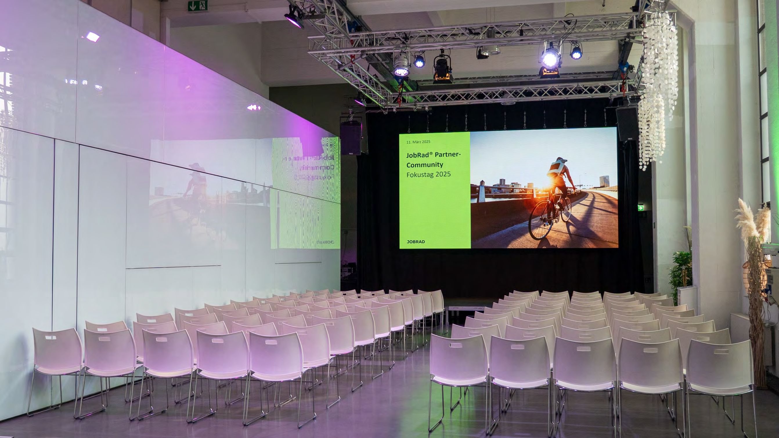 LED-Wand im Bauwerk mit Reihenbestuhlung davor