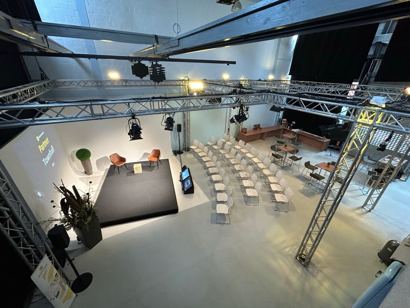 Town hall setup at Bauwerk Studio with stage, theatre seating and bar