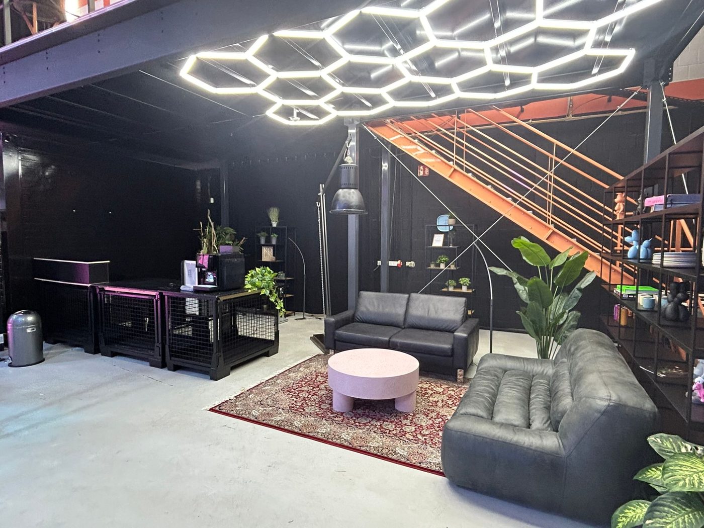 Dark lounge area beneath the gallery with honeycomb lighting