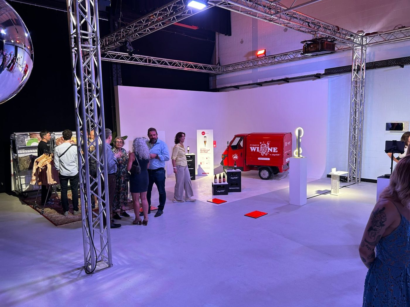 Red delivery van as an exhibit in front of the white cyclorama